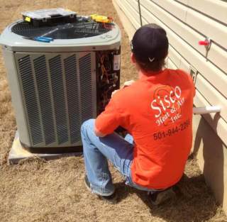 Technician performing scheduled preventive maintenance on an HVAC unit