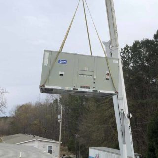 Lowering an American Standard HVAC onto a rooftop