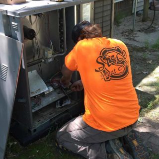 A technician hard at work on AC repair