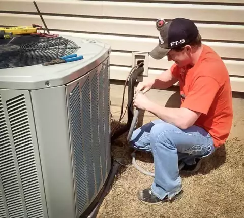 Sisco Heat & Air technician diligently working to ensure proper safety in installing this ac unit.